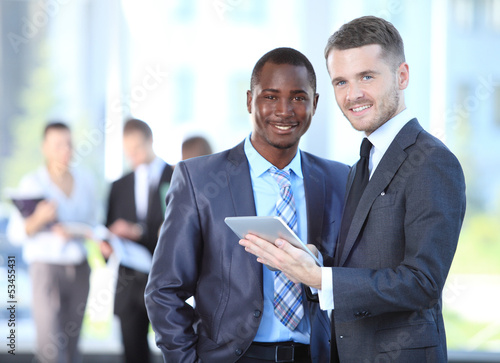 Photo: Two business men working together in the office Two business men working together in the office