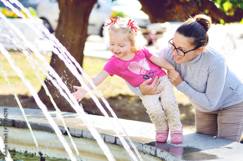 Photo: mother with baby girl near the fountain mother with baby girl near the fountain