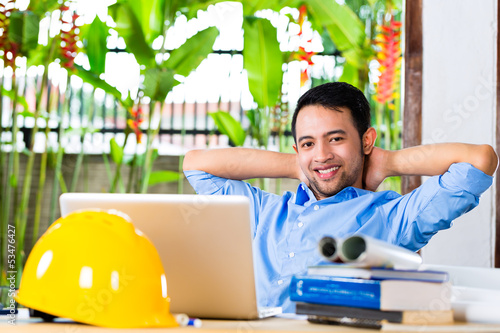Photo: Architect working at home on a design or draft Architect working at home on a design or draft