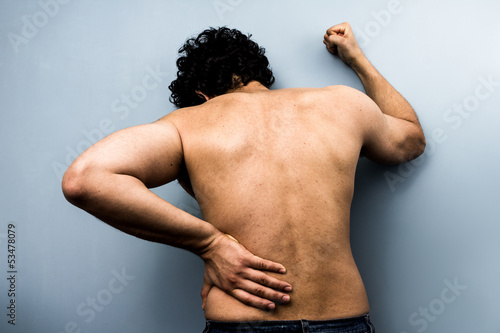 Photo: Young man with severe backpain from sciatica Young man with severe backpain from sciatica