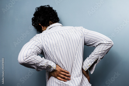 Photo: Young man with back pain Young man with back pain