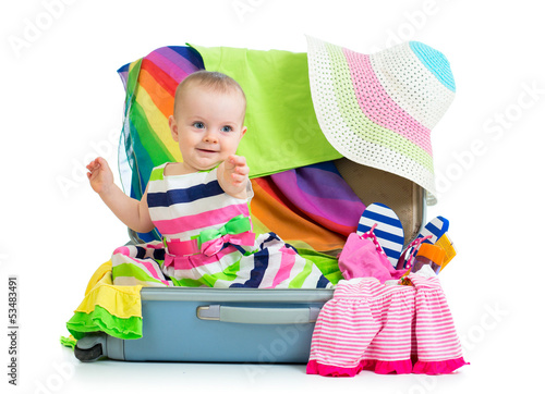 Photo: Baby girl sitting in suitcase with things for vacation travel Baby girl sitting in suitcase with things for vacation travel