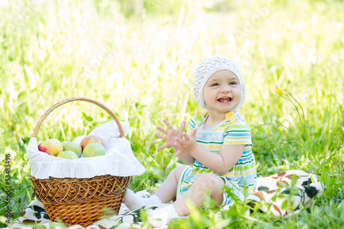 Photo: baby eating apples from basket outdoors baby eating apples from basket outdoors