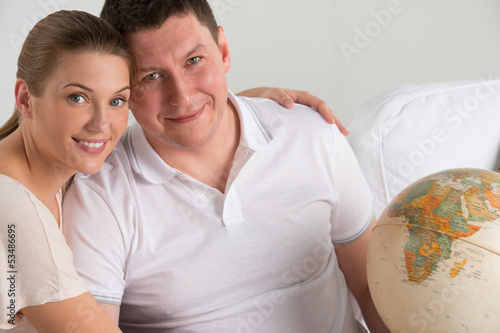 Photo: Portrait of happy romantic couple planning their vacation Portrait of happy romantic couple planning their vacation