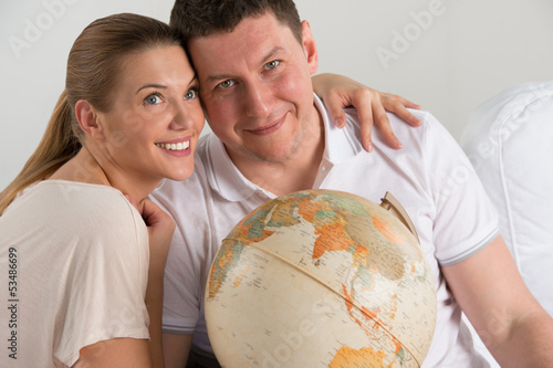Photo: Portrait of happy romantic couple planning their vacation Portrait of happy romantic couple planning their vacation
