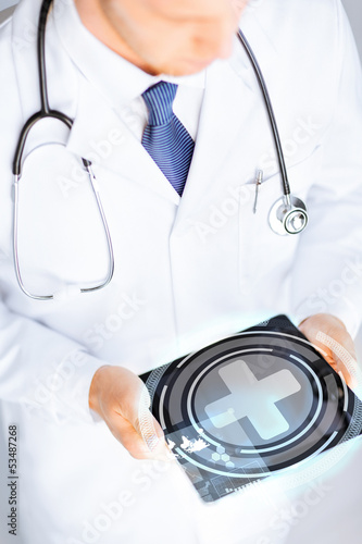 Photo: male doctor holding tablet pc with medical app male doctor holding tablet pc with medical app