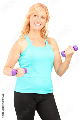 Photo: Mature smiling woman lifting up dumbbells Mature smiling woman lifting up dumbbells
