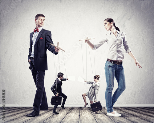 Photo: Businesspeople with marionettes Businesspeople with marionettes