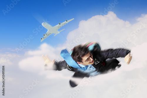 Photo: Young businessman flying with parachute on back Young businessman flying with parachute on back
