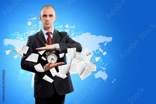 Photo: Business man holding alarmclock Business man holding alarmclock