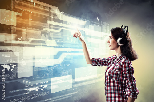 Photo: Woman touching virtual screen Woman touching virtual screen