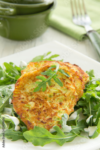 Photo: Zucchini fritters with arugula. Zucchini fritters with arugula.