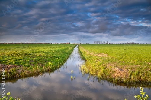 Photo: canal in Dutch farmland with reflected sky canal in Dutch farmland with reflected sky