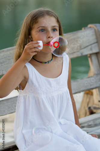Photo: Soap bubbles - lovely girl blowing bubbles Soap bubbles - lovely girl blowing bubbles