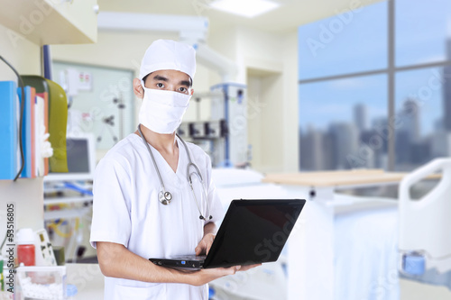 Photo: Doctor with laptop over white background Doctor with laptop over white background