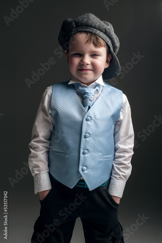 Photo: Little boy in cap and blue vest Little boy in cap and blue vest