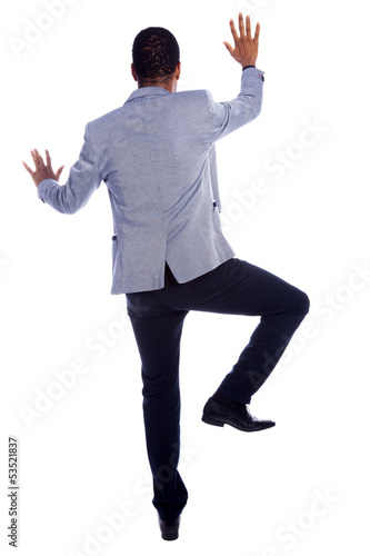 Photo: Businessman climbing a wall - isolated over a white background Businessman climbing a wall - isolated over a white background