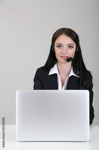 Photo: Call center operator at work, on gray background Call center operator at work, on gray background