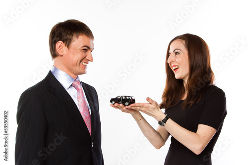 Photo: young man and woman are holding a toy car young man and woman are holding a toy car