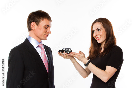 Photo: young man and woman are holding a toy car young man and woman are holding a toy car