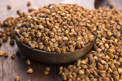 Photo: Buckwheat seeds on wooden spoon in closeup Buckwheat seeds on wooden spoon in closeup