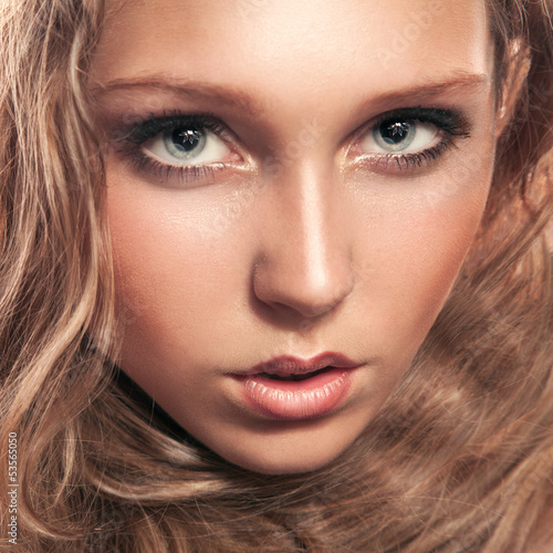 Photo: Young woman looking at camera in studio Young woman looking at camera in studio