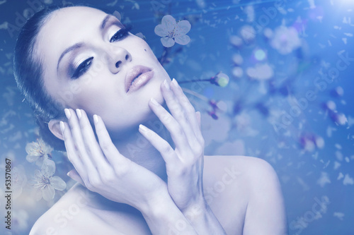 Photo: Beauty. Female outdoors portrait with floral backgrounds Beauty. Female outdoors portrait with floral backgrounds