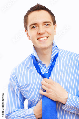 Photo: Businessman at home making his tie Businessman at home making his tie