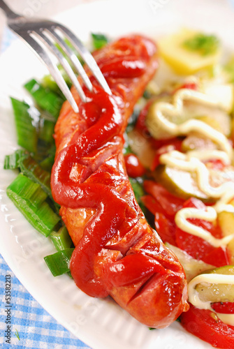 Photo: grilled sausage with ketchup and vegetable salad grilled sausage with ketchup and vegetable salad