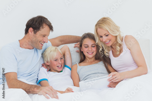 Photo: Cheerful family using digital tablet Cheerful family using digital tablet