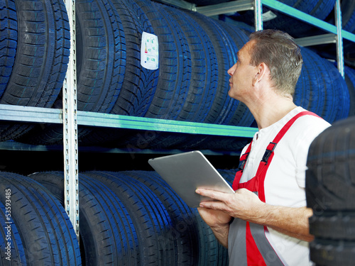 Photo: Master mechanic is looking for the right tire with touchpad Master mechanic is looking for the right tire with touchpad