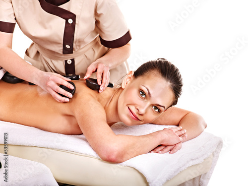 Photo: Woman getting stone therapy massage . Woman getting stone therapy massage .
