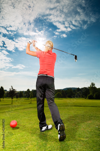 Photo: Young golf player on course doing golf swing Young golf player on course doing golf swing