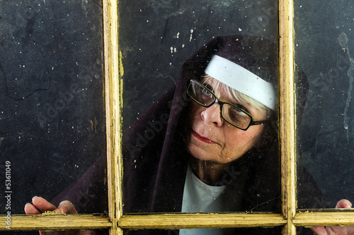 Photo: nun looking through a window nun looking through a window