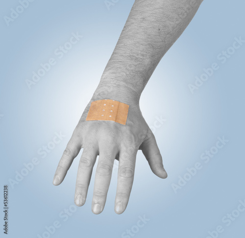 Photo: Putting a small adhesive, bandage on a arm Putting a small adhesive, bandage on a arm