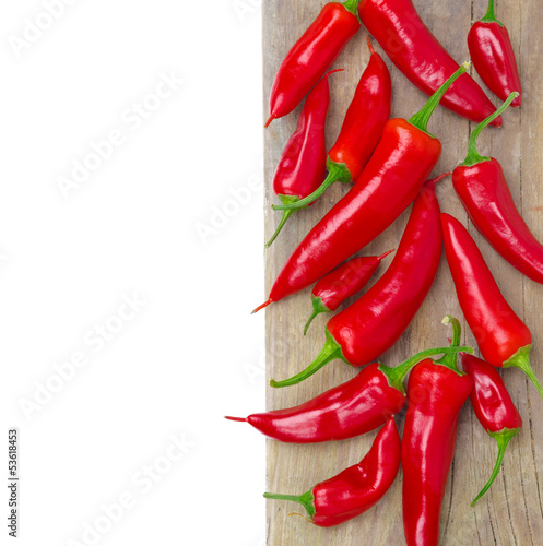 Photo: red hot chili peppers on a wooden board, isolated, close-up red hot chili peppers on a wooden board, isolated, close-up