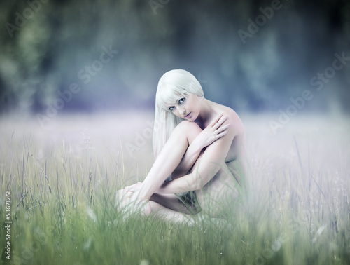 Photo: Young sexy woman sitting on meadow Young sexy woman sitting on meadow