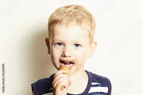 Photo: smiling child. cute kid boy eating ice cream. smiling child. cute kid boy eating ice cream.