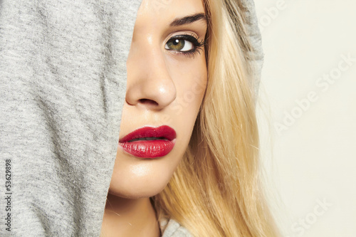 Photo: beautiful blond woman in hood. red lips. text here beautiful blond woman in hood. red lips. text here