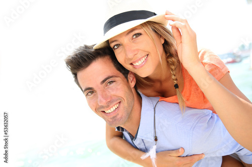 Photo: Man giving piggyback ride to beautiful blond girl with hat Man giving piggyback ride to beautiful blond girl with hat