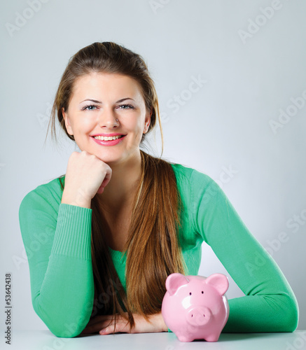Photo: Young beautiful woman with piggy bank (money box) Young beautiful woman with piggy bank (money box)