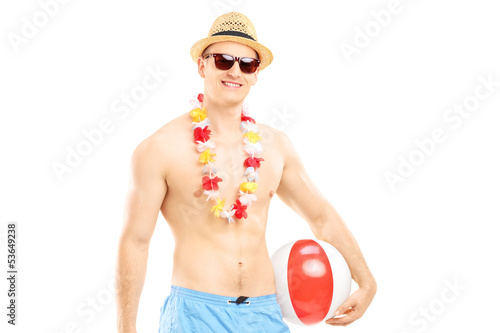 Photo: Fit man in swimming shorts, holding a beach ball Fit man in swimming shorts, holding a beach ball