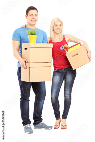 Photo: Full length portrait of a young male and female holding boxes Full length portrait of a young male and female holding boxes