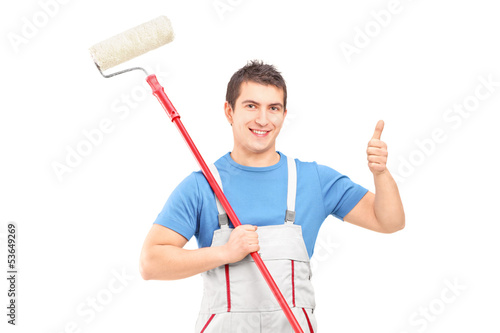 Photo: Male painter holding a roller and giving a thumb up Male painter holding a roller and giving a thumb up