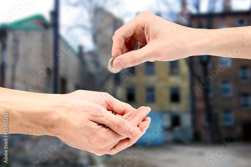 Photo: Hand gives coin to beggar on the street Hand gives coin to beggar on the street