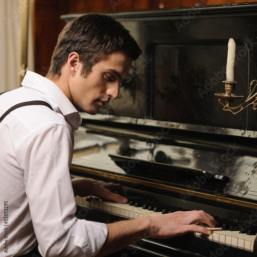 Photo: Making music. Profile of a handsome young men playing piano Making music. Profile of a handsome young men playing piano
