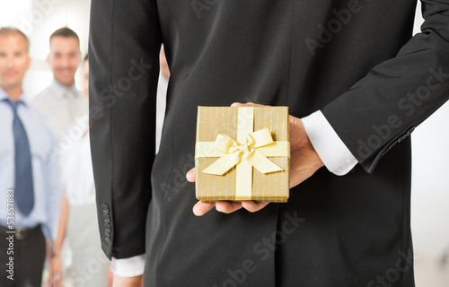 Photo: man hands holding gift box in office man hands holding gift box in office