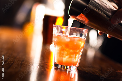 Photo: Barman pouring a cocktail into a glass Barman pouring a cocktail into a glass