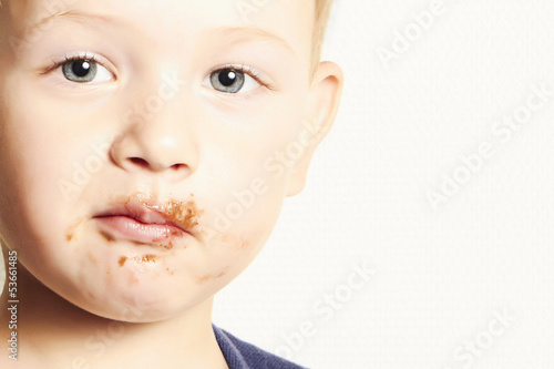 Photo: portrait of child. kid boy with chocolate dirty face portrait of child. kid boy with chocolate dirty face