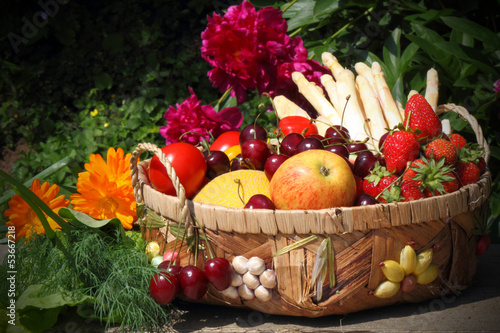 Photo: Korb mit Obst und Gemüse vor Pfingstrosen Korb mit Obst und Gemüse vor Pfingstrosen